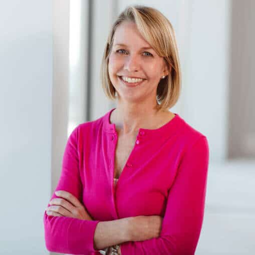 financial advisor with folded arms in pink shirt