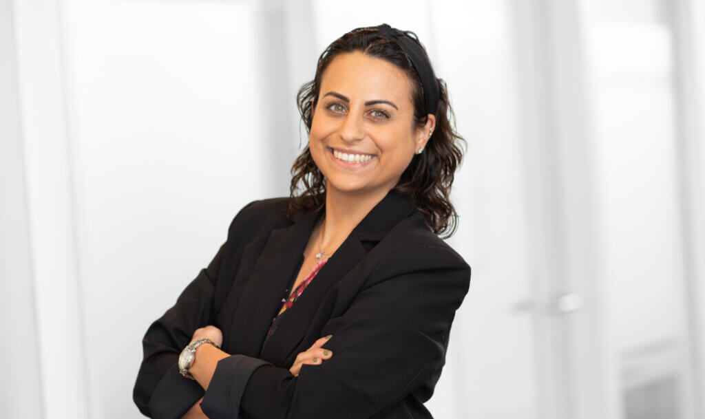 women in black blazer with arms crossed